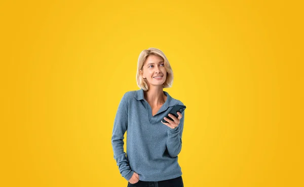 Dreaming Smiling Woman Portrait Using Phone Empty Copy Space Yellow — Stok fotoğraf