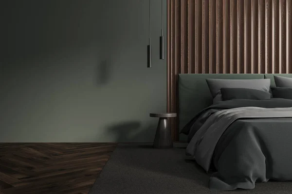 Interior of stylish bedroom with green walls, wooden floor, comfortable king size bed with dark gray cover standing on gray carpet and copy space wall on the left. 3d rendering