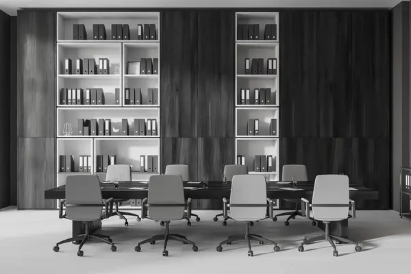 Black wooden office interior with meeting table, armchairs on grey concrete floor. Conference zone for negotiation, shelf with business folders. 3D rendering