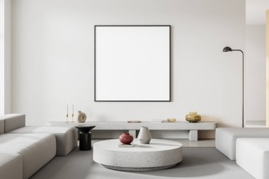 Beyaz duvarları, beton zemini, yuvarlak sehpanın yanında duran rahat beyaz kanepe ve kare şeklindeki afişi olan şık bir oturma odası. 3d oluşturma