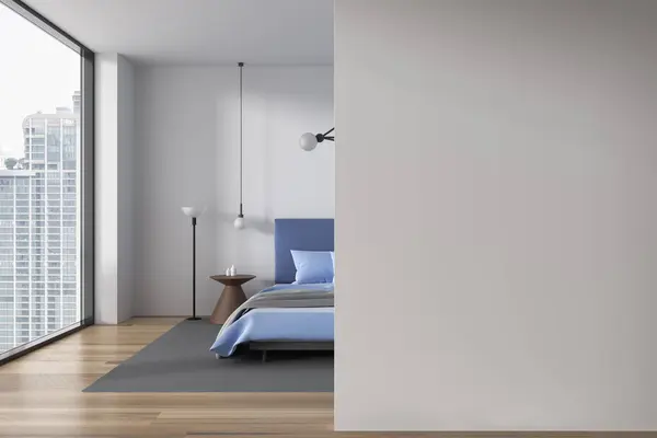 Interior of modern bedroom with white walls, wooden floor, comfortable king size bed with blue cover and copy space wall on the left. 3d rendering