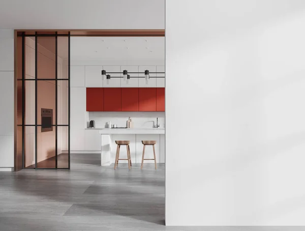 Interior of stylish kitchen with white walls, concrete floor, red cupboards, white cabinets, comfortable white island with stools and copy space wall on the right. 3d rendering