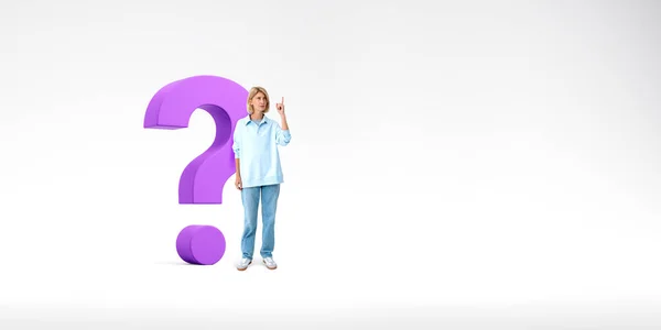 Young European woman pointing upwards standing near big purple question mark over white copy space background. Concept of curiosity