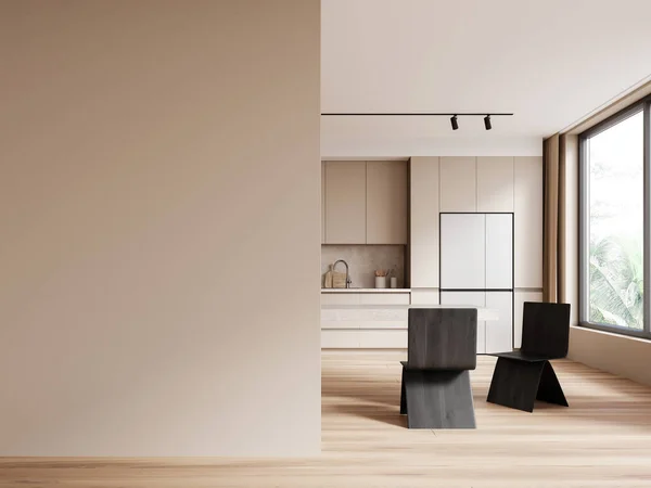 Interior of modern kitchen with beige walls, wooden floor, beige cupboard and cabinets, big fridge and long dining table with black chairs. Copy space wall on the left. 3d rendering