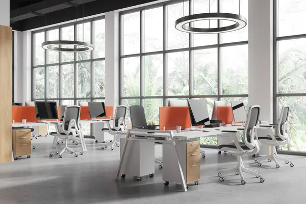 Corner view of office loft interior with pc computers, coworking corner with armchairs and desk with partition. Workspace with furniture in row and panoramic window. 3D rendering