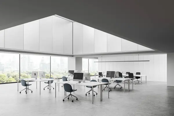 Modern office loft interior with pc monitors, coworking corner with armchairs and desk in row on grey concrete floor. Open space workplace with panoramic window on skyscrapers. 3D rendering