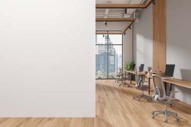 Gri ve beyaz duvarları, ahşap zemini ve bej sandalyeli sıra sıra bilgisayar masaları olan modern açık uzay ofisinin içi. Soldaki uzay duvarını kopyala. 3d oluşturma