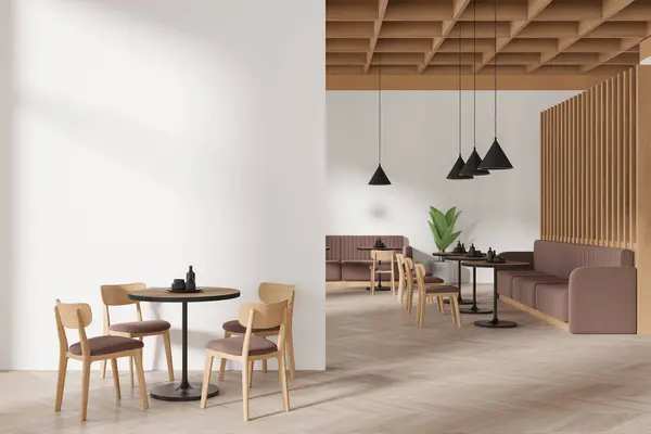 Interior of stylish restaurant with white walls, wooden floor, comfortable round tables with brown chairs and cozy beige sofas. Copy space wall on the left. 3d rendering