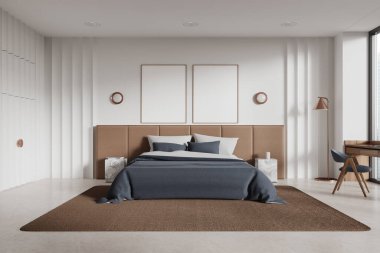 Modern yatak odasının içinde beyaz duvarlar, beton zemin, rahat kral yatağı mavi kapaklı ve pencerenin yanında duran tahta masa. İki dikey maket poster. 3d oluşturma