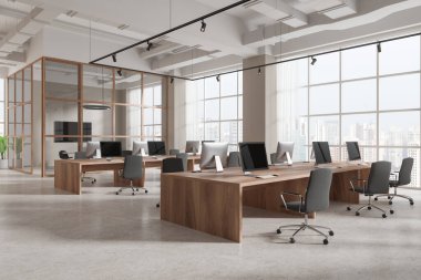 Beyaz ve bej duvarları, beton zemini ve gri sandalyeli ahşap bilgisayar masaları olan modern açık uzay ofisinin köşesi. 3d oluşturma