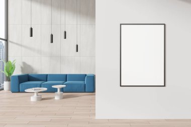 Beyaz duvarları, ahşap zemini, yuvarlak sehpaların yanında duran rahat mavi kanepesi ve dikey poster çerçevesi olan şık bir oturma odası. 3d oluşturma
