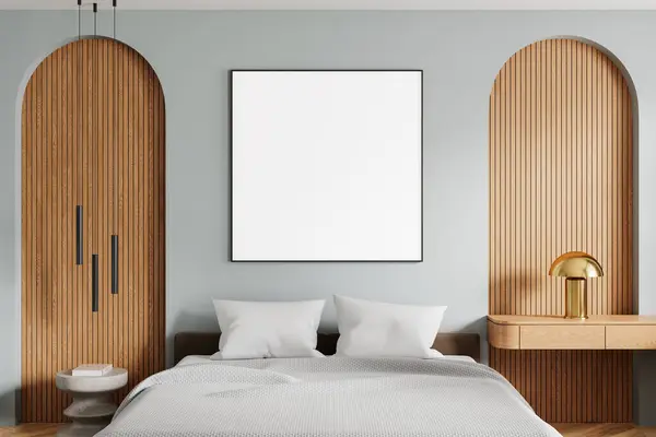 Interior of modern bedroom with gray walls, wooden floor, comfortable king size bed with two bedside tables and square mock up poster on the wall. 3d rendering