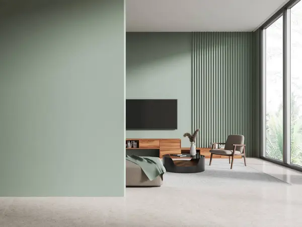Interior of stylish living room with green walls, concrete floor, comfortable gray sofa and armchair and modern TV set on the wall. Copy space wall on the left. 3d rendering