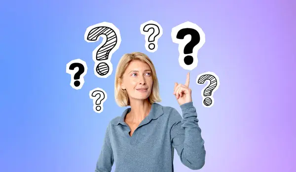 Smiling beautiful blonde woman finger point at doodle question marks, gradient background. Concept of problem solving, solution, idea, startup and business plan