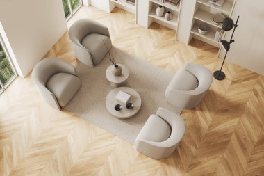 Bej renkli ev oturma odasının en üst manzarası dört koltuk ve kahve masası, sanat dekorasyonlu minimalist raf ve ahşap zeminde kitaplar. Tropik bölgelerde panoramik pencere. 3B görüntüleme