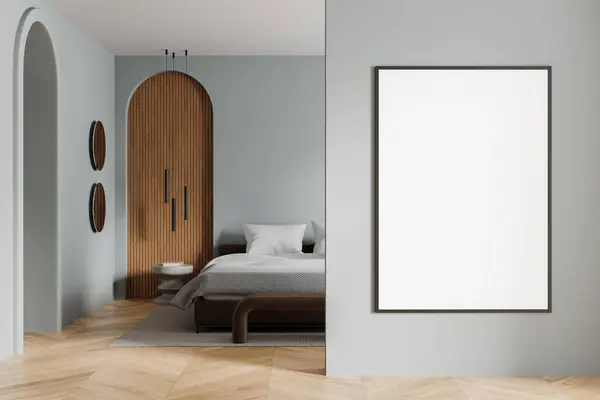 Interior of modern bedroom with gray walls, wooden floor, comfortable king size bed with two bedside tables and vertical mock up poster on the wall. 3d rendering