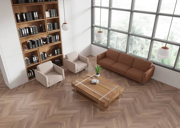 Top view of modern office waiting room interior with white walls, wooden floor, comfortable sofa and armchairs standing near coffee table and bookcase. 3d rendering
