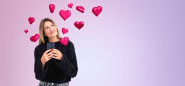 Mor fotokopi arkaplanı üzerinde sosyal medya simgeleri olan akıllı telefonlu mutlu genç bir kadının portresi. Çevrimiçi iletişim kavramı