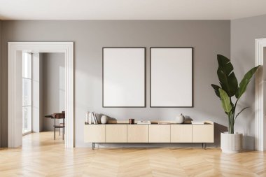 Gri duvarları, ahşap zemini, rahat ahşap şifoniyeri ve üzerinde asılı iki dikey maket posteriyle modern oturma odasının içi. 3d oluşturma