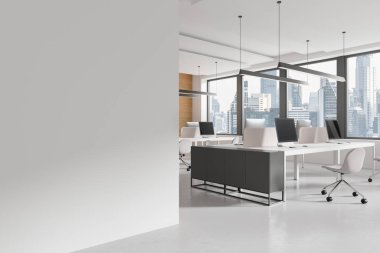 Yan yana çalışan bilgisayarlarla yan yana sıralanmış masalar, aydınlık beton zemin. Bangkok 'ta panoramik pencereli bir ofis. Boş duvar bölmesini düzenle. 3B görüntüleme
