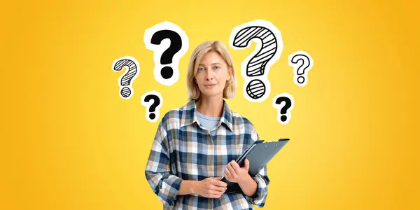 Smiling beautiful blonde woman portrait with clipboard in hands, doodle question marks row on yellow background. Concept of problem solving, solution, idea, startup and business plan