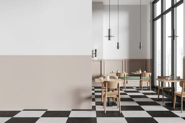 stock image Interior of stylish minimalistic restaurant with white and beige walls, square tables and checkered floor. Wooden chairs and green sofas. Copy space template. 3d rendering