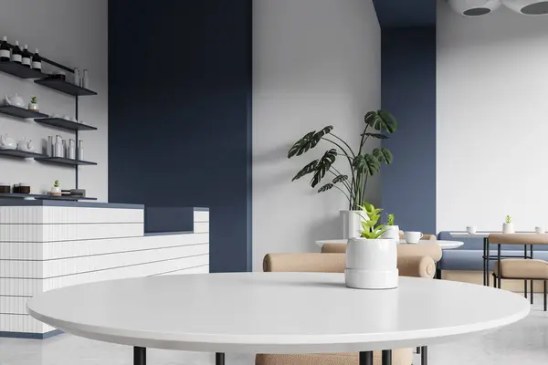 Corner view of white and blue cafe interior with close up dinner table, bar island and shelf with kitchenware. Minimalist cafe design with eating space and plant. 3D rendering