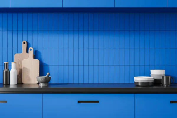 Stylish blue home kitchen interior with dishes and kitchenware on counter, cutting board, spices and plates. Closeup of colored cooking area with tile wall. 3D rendering