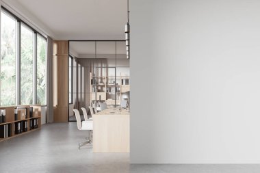 Gri ve ahşap duvarları, beton zemini, ahşap bilgisayar masaları ve şehir silueti olan panoramik pencereli şık bir açık uzay ofisi. Sağ taraftaki uzay duvarını kopyala. 3d oluşturma