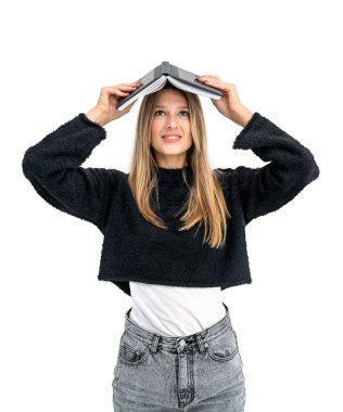 Tişört ve kot pantolon giymiş, elinde kitapla gülümseyen genç bir kadın. Beyaz arka planda izole edilmiş. Öğrenci, üniversite ve işletme fakültesi kavramı