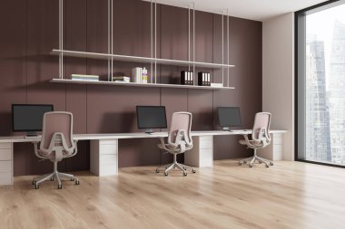 Şehir manzarasına karşı masaları, sandalyeleri ve monitörleri olan, kahverengi tonları baskın olan modern bir ofis alanı. 3B Hazırlama