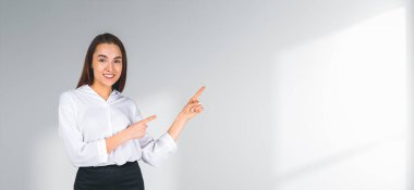 Boş beyaz duvar arkaplanını gösteren kadın, kopya alanı ile ilgili bir kavram sergiliyor