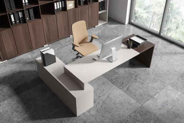 Çalışma masası, bilgisayar ve gri kiremit beton zemin ile CEO 'nun iç görüntüsü. Şık danışma alanı ve klasörlü raf. Tropik bölgelerde panoramik pencere. 3B görüntüleme