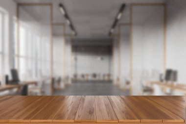 Ön planda ahşap masa, koltuklar ve bilgisayarlarla bulanık iç mekan, panoramik pencereli ofis dairesi. Ürün gösterimi için bir model. 3B görüntüleme