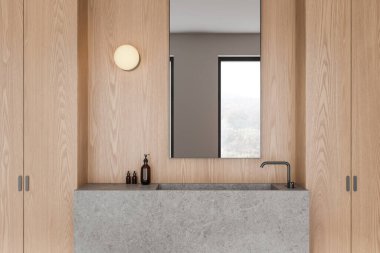 Ahşap duvarları, beton bir lavabosu ve büyük bir aynası olan modern bir banyo. Lavaboda iki küçük şişe ve bir sabun makinesi var. Minimalist tasarım konsepti. 3B Hazırlama.