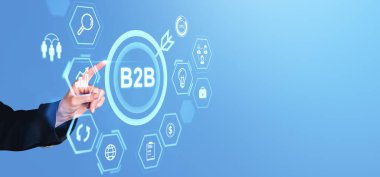 İş dünyası kavramlarını ve teknolojiyi temsil eden mavi arkaplanlı dijital arayüzdeki B2B simgelerini elle göstererek