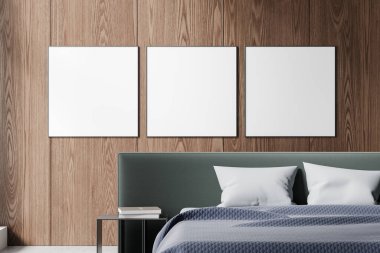 Minimalist ev yatak odası ketenli yatak odası, kitaplarla çevrili komodin. Ahşap duvarda üç tane kare tuval posterleri var. 3B görüntüleme