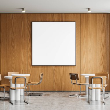 Yuvarlak yemek masaları, sandalyeleri ve parlak beton zemini olan minimalist bir kafe. Şık restoran yeme alanı. Ahşap duvarda geniş kare bir tuval var. 3B görüntüleme