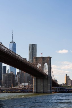 Brooklyn Köprüsü, Manhattan gökdelenleri ve arka planda açık gökyüzü ile East River 'ın üzerine uzanır. Kentsel manzara kavramı, New York