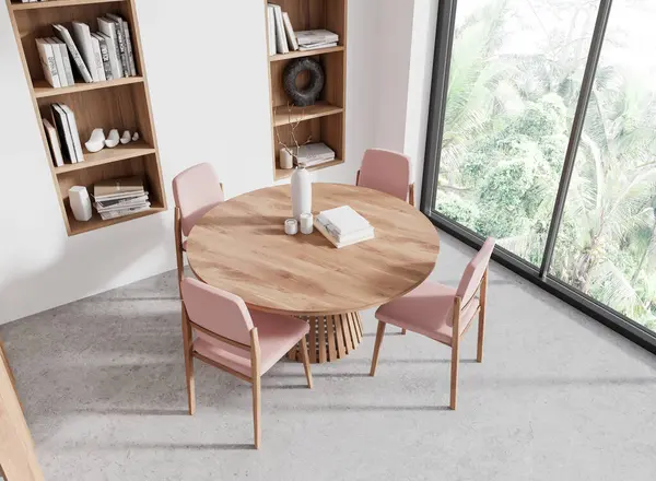 Pembe sandalyeli, yuvarlak yemek masalı, beton zeminli ev oturma odası manzarası. Tropik bölgelerde panoramik pencere. Kitapları ve süslemeleri olan raflar. 3B görüntüleme