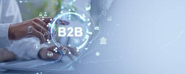 Bir iş adamının eli B2B holografik arayüzünü işaret ediyor. Açık mavi arkaplan. İş teknolojisi ve strateji iletişimi kavramı