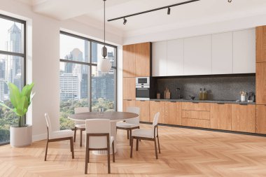 İçinde ahşap dolaplar, sandalyeli yuvarlak bir yemek masası ve şehir manzaralı geniş pencereler olan modern bir mutfak. Çağdaş, şık bir ev dekorasyonu konsepti sergiliyor. 3B Hazırlama