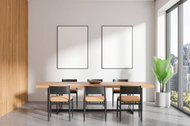 Ahşap bir masası, sandalyeleri ve beyaz bir duvarda boş çerçeveli posterleri olan modern bir yemek odası. Şehir manzaralı büyük bir pencere. İç tasarım kavramı. 3B Hazırlama