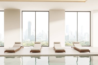 Şehir manzaralı geniş pencerelere karşı modern şezlongların olduğu kapalı yüzme havuzu alanı. Lüks bir ortamda çağdaş tasarım. 3B Hazırlama.