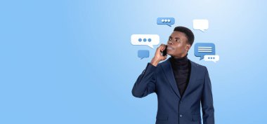 Concentrated black businessman talking on the phone, portrait on copy space blue background. Text message chat bubbles and clouds. Concept of online communication, network and social media clipart