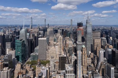 Manhattan gökdelenlerinin gökdelenleri mavi gökyüzünün altında dağınık bulutlarla birlikte. ABD 'nin New York şehrinin manzarasını betimliyor.
