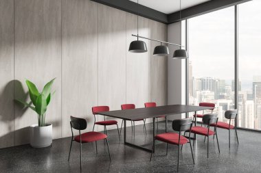 Ahşap masası, kırmızı sandalyeleri ve saksısı olan modern konferans odası. Büyük pencerelerden şehrin ufuk çizgisi manzaralı zarif bir iç tasarım. 3B Hazırlama