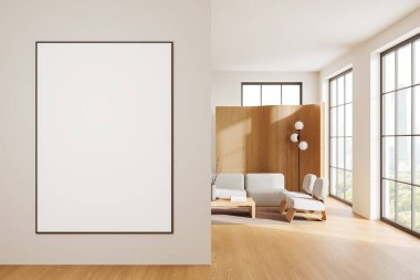 Modern bir oturma odasında, ahşap aksanlı, geniş pencereli ve minimalist mobilyalı boş bir poster modeli çerçevelenmiş. 3B Hazırlama