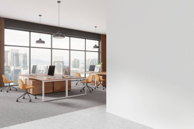 Geniş pencereli modern ofis, bilgisayarlı masalar ve sağda model şablonu için boş beyaz bir duvar. 3B Hazırlama