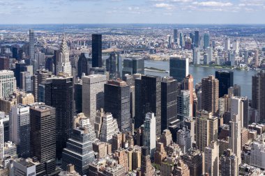 Manhattan 'ın gökdelenlerini gösteren bir hava görüntüsü. Gökdelenler, canlı şehir manzarası, berrak mavi bir arka plan.